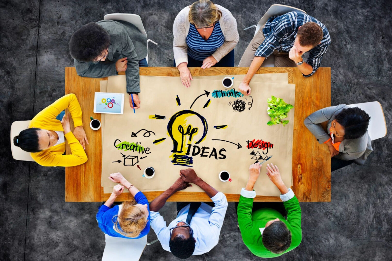 A group of people sitting around a table with an idea sign on it.