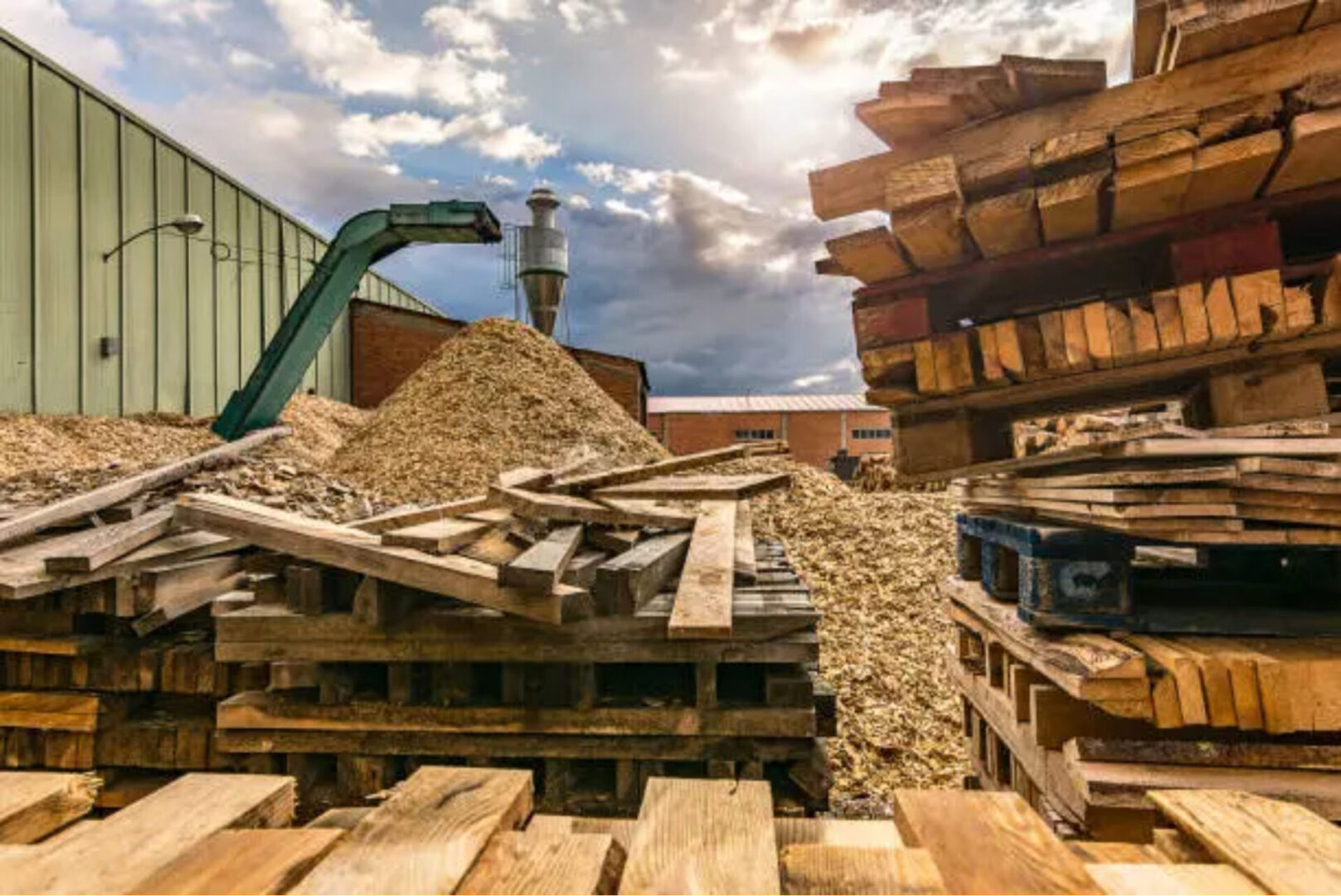 A pile of wood sitting on top of a dirt field.