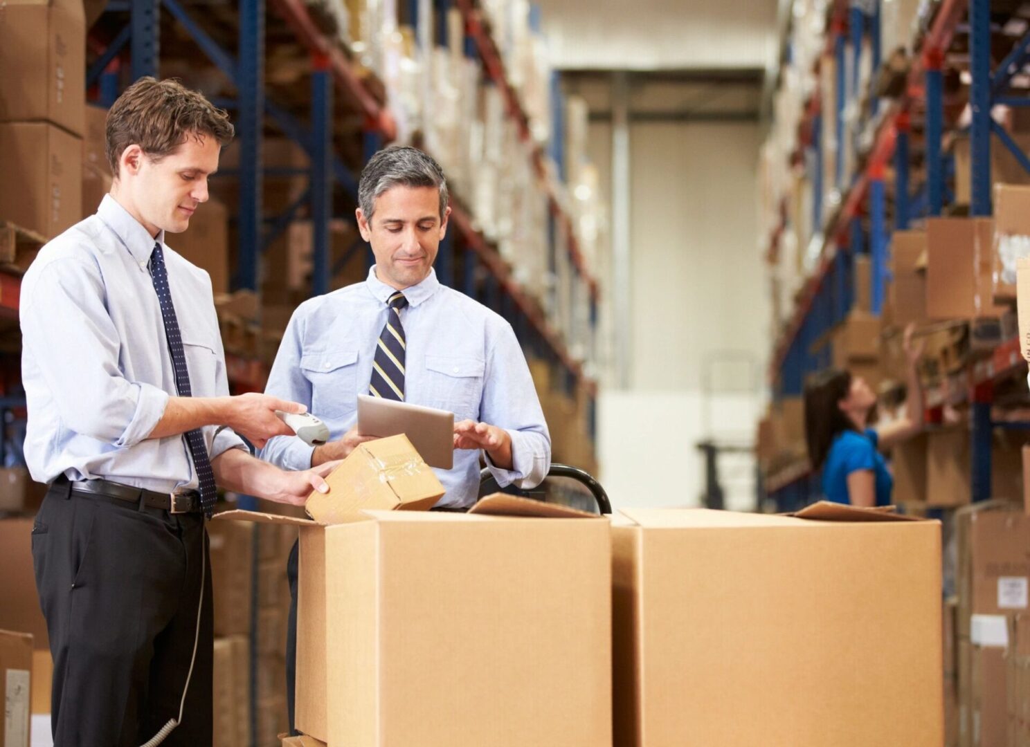 Two men in a warehouse looking at boxes.