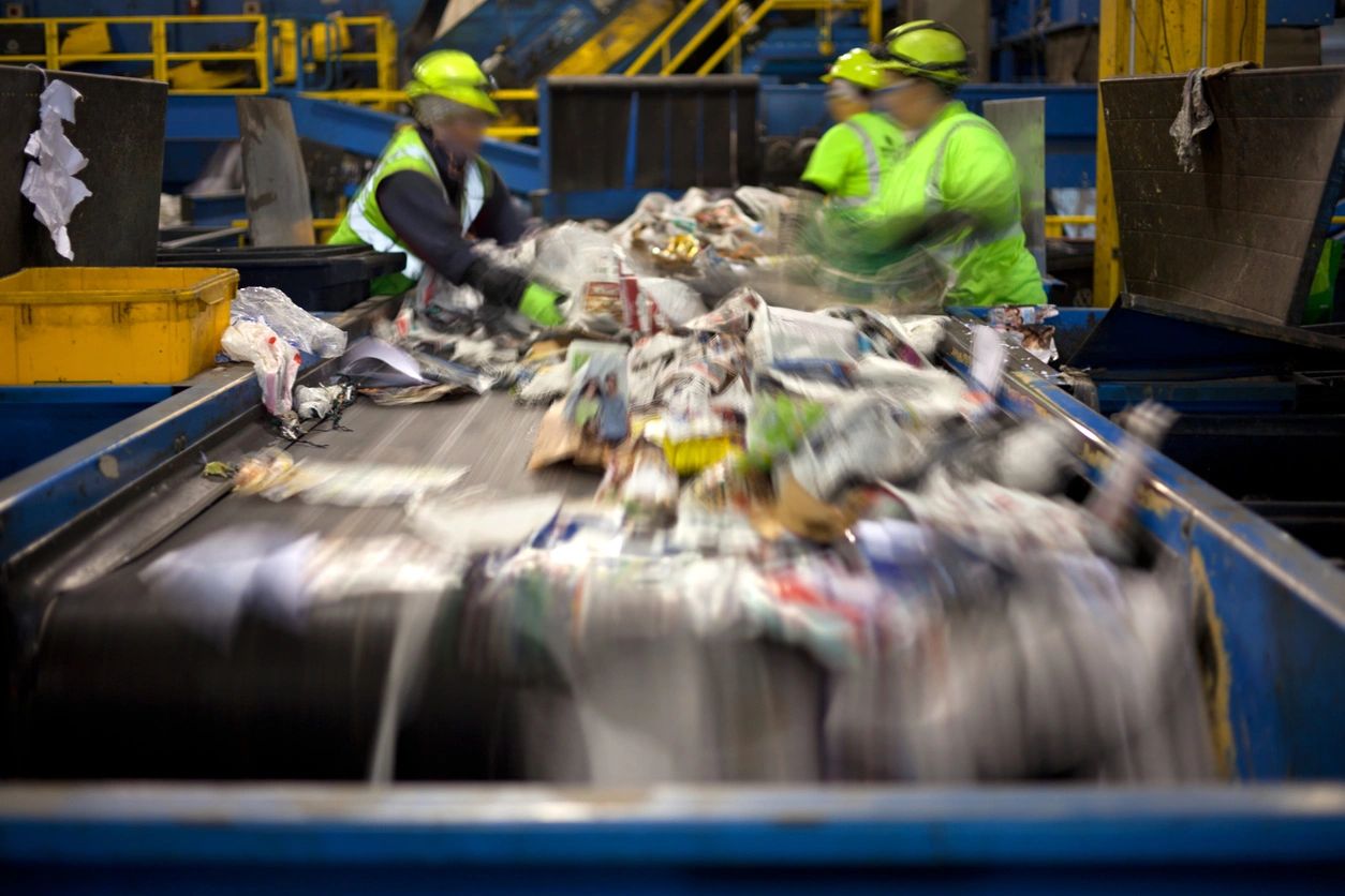 Two men working in a recycling center.