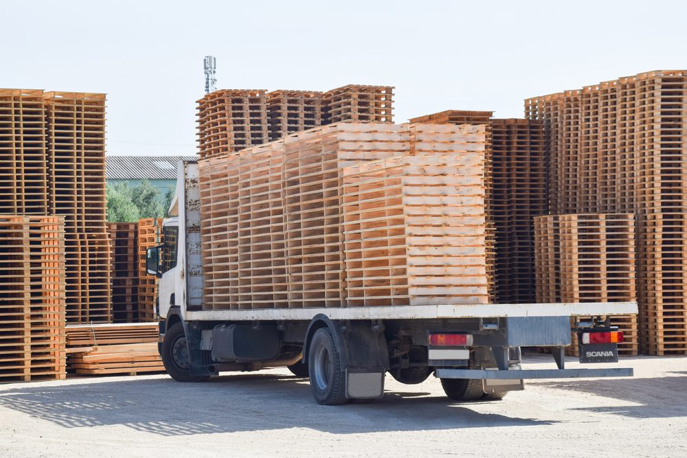 A truck with pallets on the back of it.